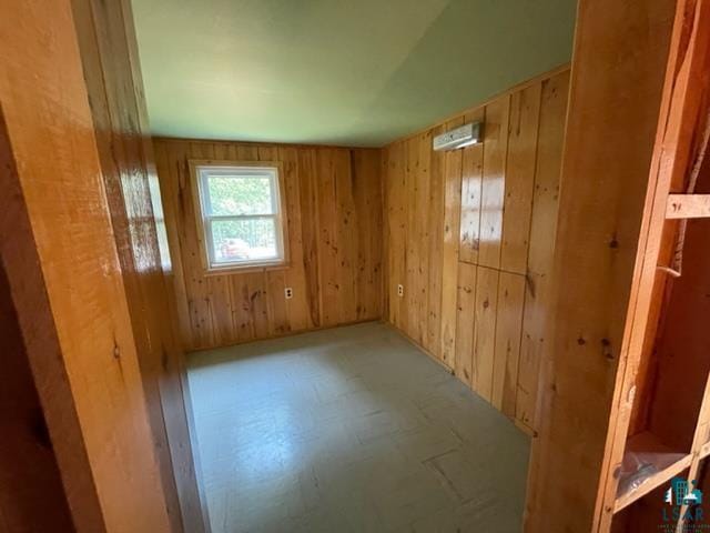 unfurnished room featuring wood walls