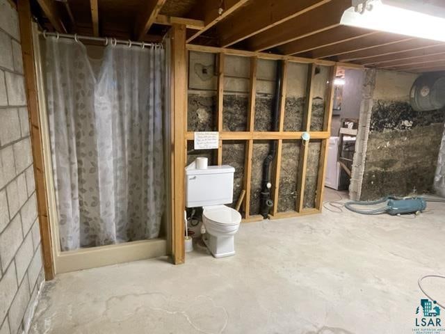 bathroom with toilet and concrete flooring