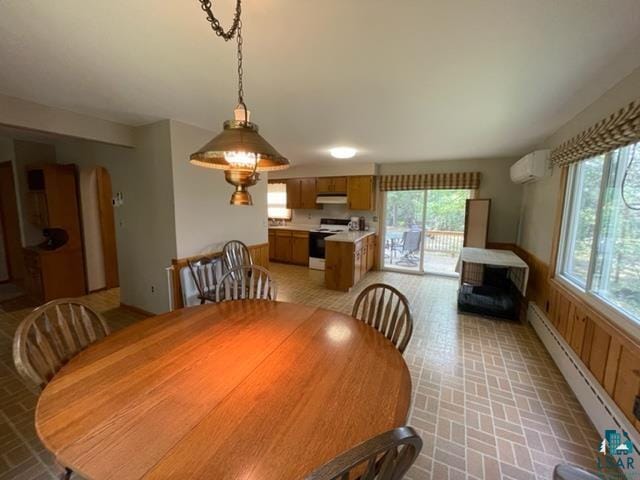 dining space with plenty of natural light, baseboard heating, and a wall mounted air conditioner