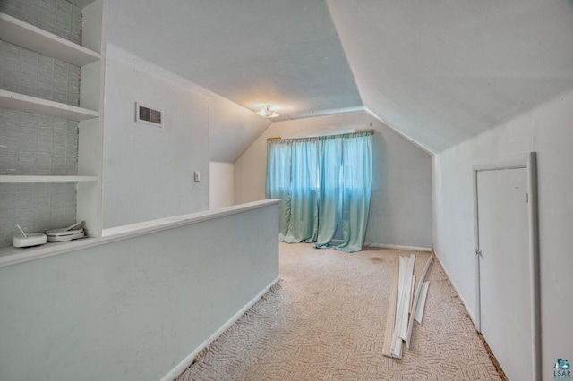 additional living space featuring lofted ceiling and light carpet