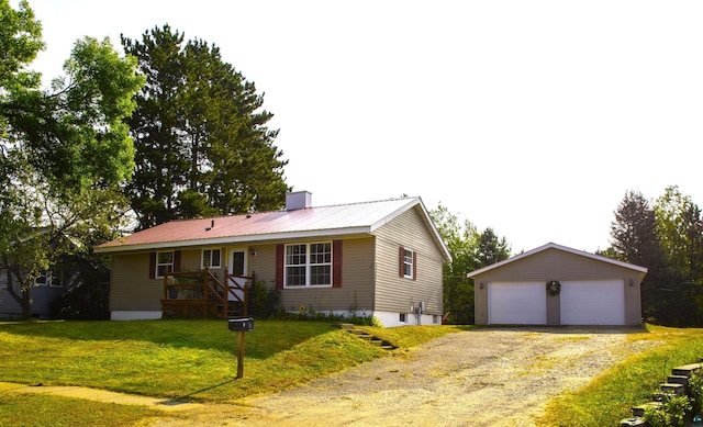 ranch-style home with a garage, a front lawn, and an outbuilding