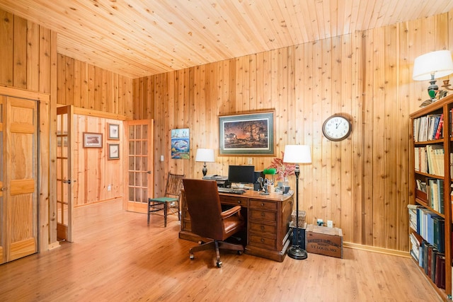 office with light wood-type flooring, wooden walls, and wooden ceiling