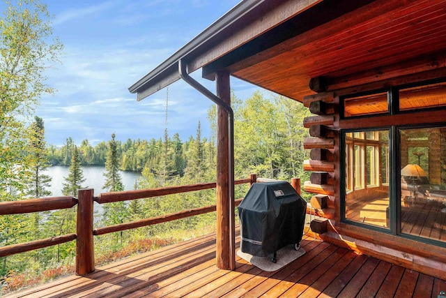 wooden terrace featuring a water view and a grill