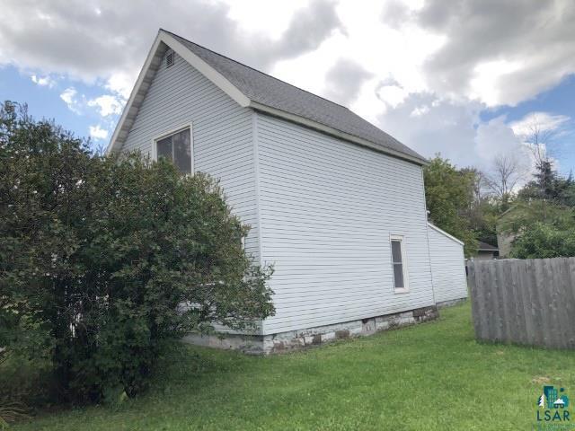 view of side of home with a yard