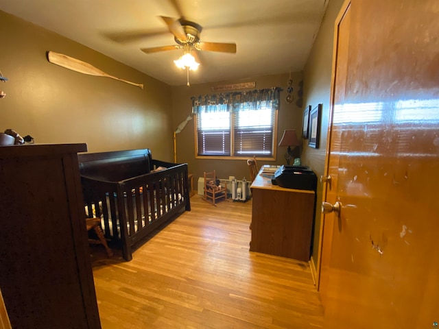 bedroom with light wood-type flooring and a nursery area