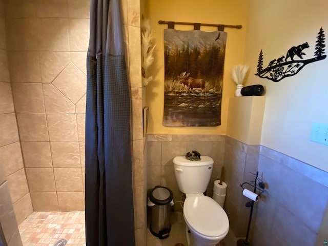 bathroom featuring tile walls, curtained shower, and toilet