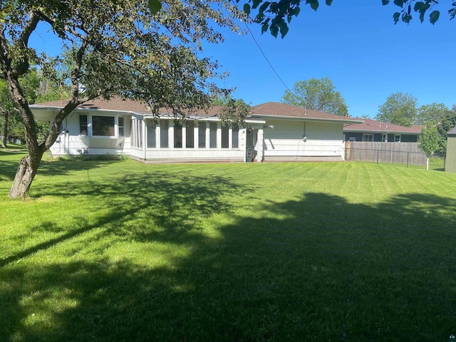 rear view of property with a lawn