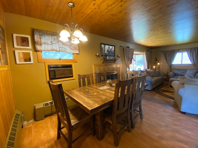 dining space with wood ceiling, a fireplace, radiator heating unit, hardwood / wood-style floors, and a chandelier