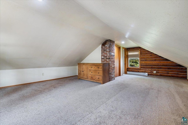 bonus room with a textured ceiling, vaulted ceiling, baseboard heating, and carpet floors