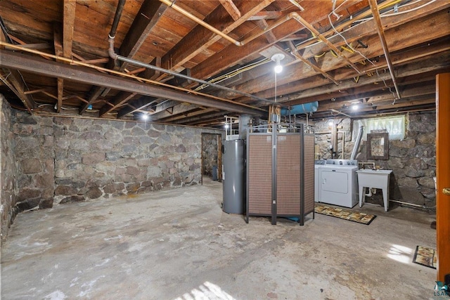 basement featuring water heater, sink, and washing machine and dryer