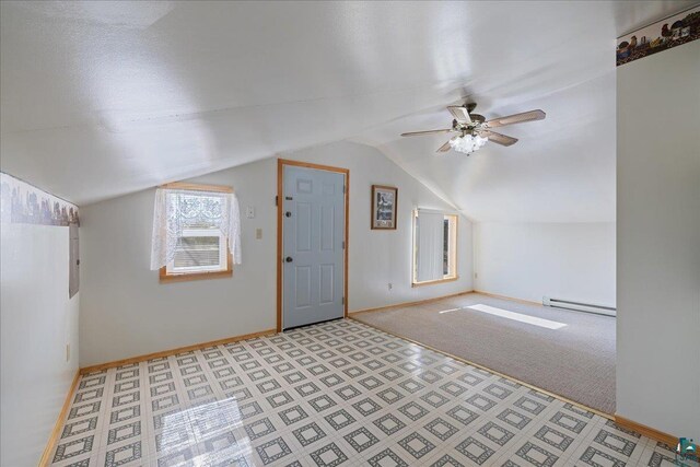 additional living space with a baseboard radiator, vaulted ceiling, ceiling fan, and light colored carpet