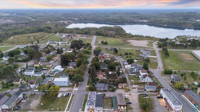 aerial view at dusk featuring a water view