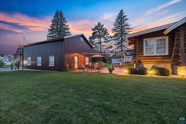 property exterior at dusk featuring a patio and a yard