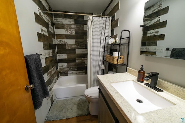 full bathroom with hardwood / wood-style floors, vanity, shower / bath combo with shower curtain, and toilet