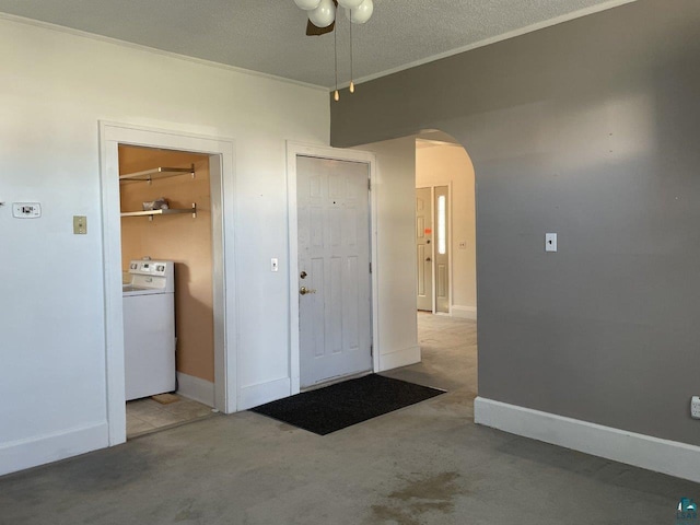 foyer featuring a textured ceiling, washer / clothes dryer, and ceiling fan