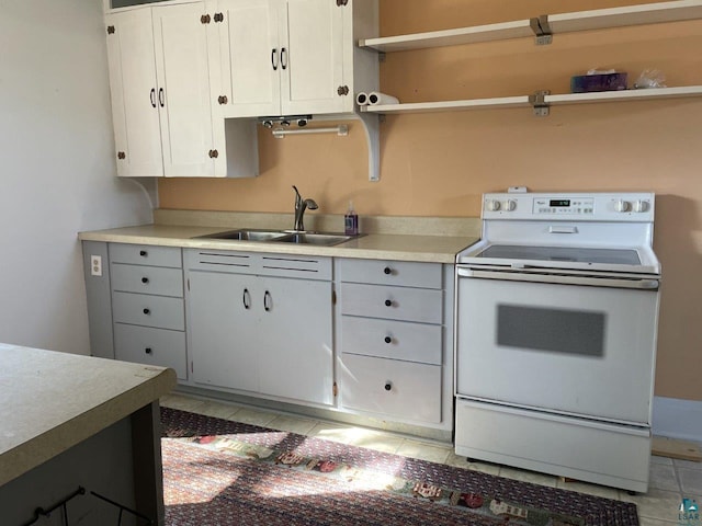 kitchen with light tile patterned floors, white cabinets, white electric range oven, and sink