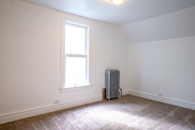 additional living space with radiator, carpet, and lofted ceiling