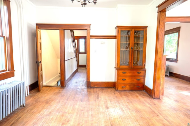 interior space featuring light hardwood / wood-style floors, radiator heating unit, and ornamental molding