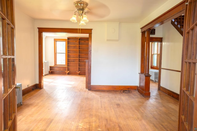 spare room with radiator heating unit, light hardwood / wood-style floors, and ceiling fan