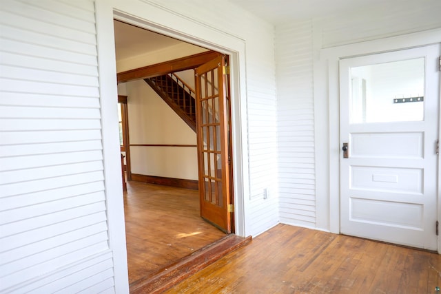 hallway with wooden walls and dark wood-type flooring