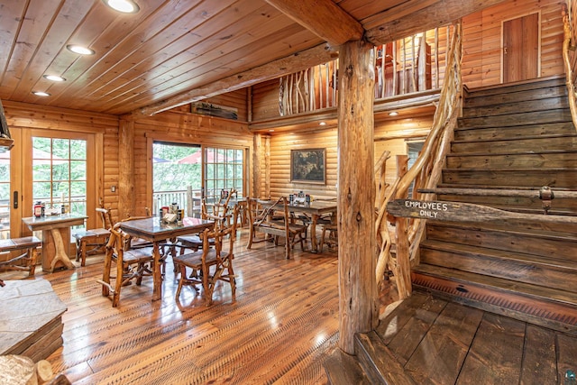 dining space featuring beam ceiling, wood ceiling, log walls, and hardwood / wood-style floors