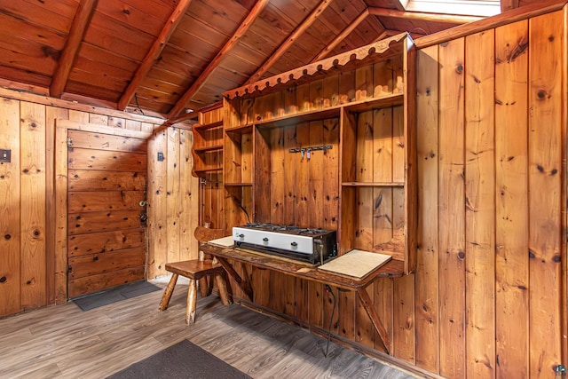 interior space with wood-type flooring, wood ceiling, lofted ceiling with beams, and wood walls