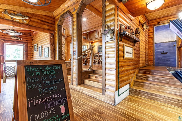 interior space with wood ceiling, log walls, and hardwood / wood-style flooring