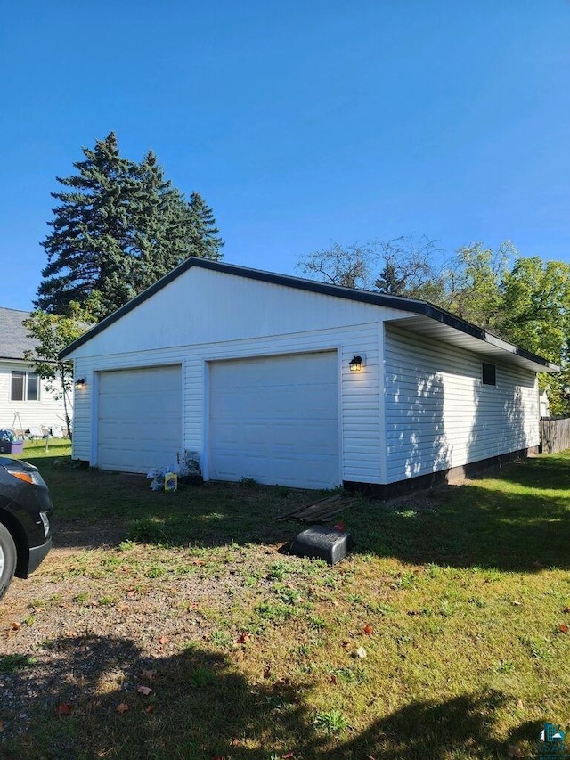 view of side of property with a lawn, an outdoor structure, and a garage