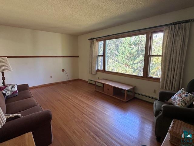 living room with a textured ceiling, baseboard heating, and hardwood / wood-style flooring