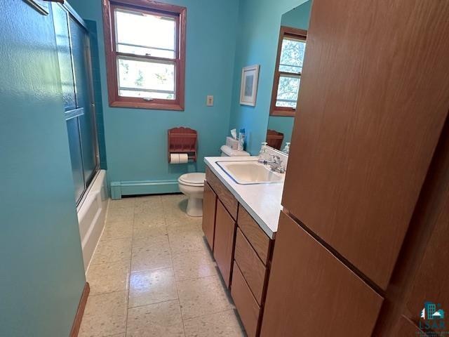 full bathroom featuring shower / bath combination with glass door, vanity, toilet, and a baseboard radiator