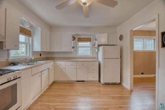 kitchen with light wood-type flooring, white appliances, sink, and white cabinets