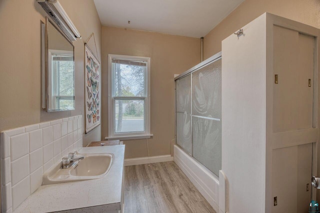 bathroom with decorative backsplash, shower / bath combination with glass door, vanity, and hardwood / wood-style flooring