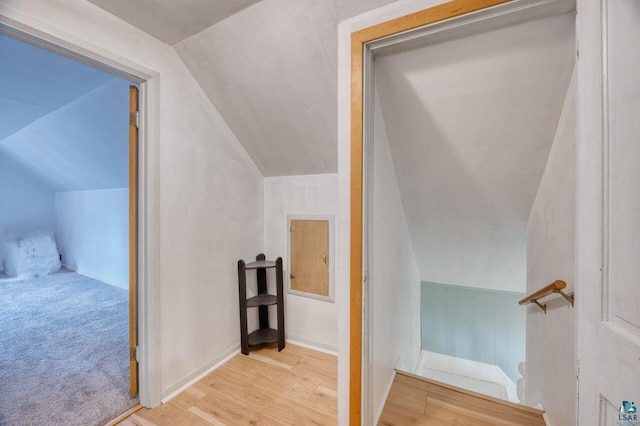 stairway featuring vaulted ceiling and hardwood / wood-style floors