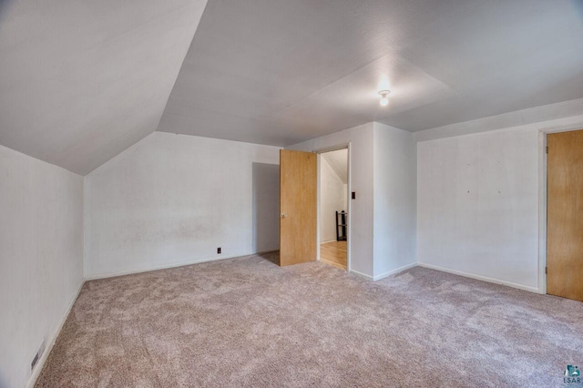 additional living space with vaulted ceiling and light colored carpet