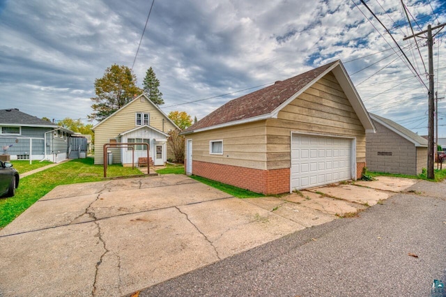 bungalow-style home featuring a garage and an outbuilding