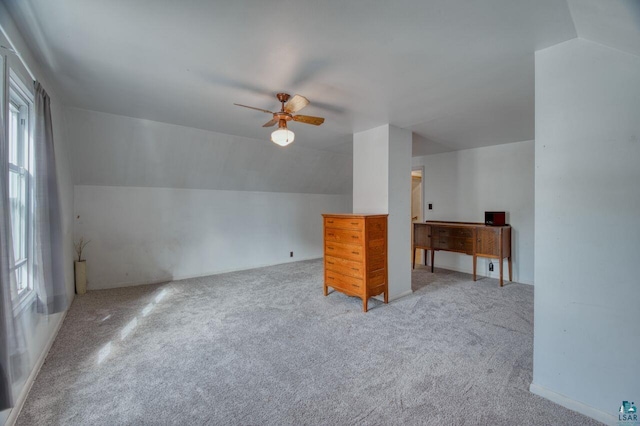 bonus room with lofted ceiling, ceiling fan, light colored carpet, and a healthy amount of sunlight