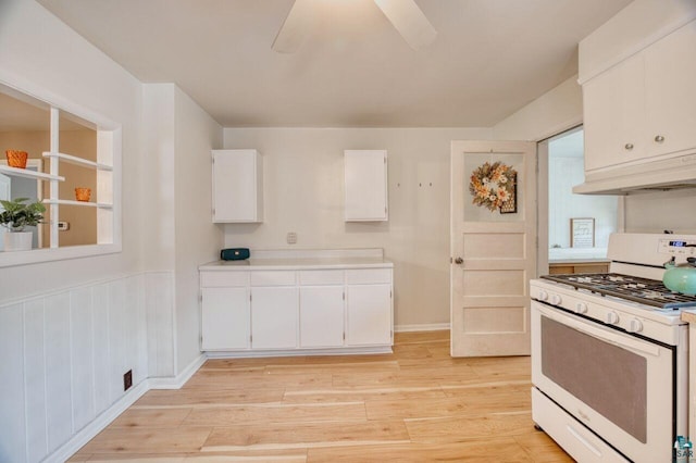 kitchen with ceiling fan, white cabinets, white range with gas stovetop, and light hardwood / wood-style floors