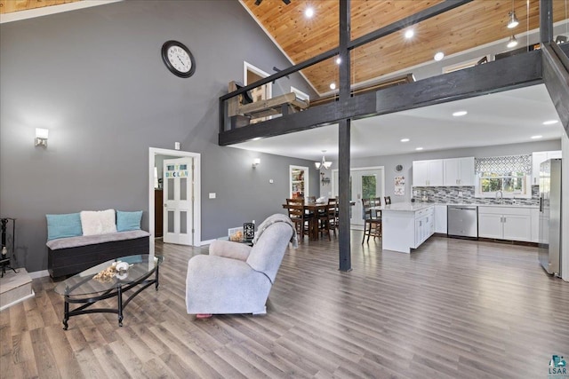 living room with high vaulted ceiling, wood ceiling, hardwood / wood-style floors, and sink