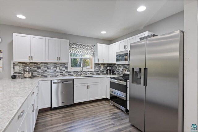 kitchen with sink, white cabinetry, decorative backsplash, appliances with stainless steel finishes, and dark hardwood / wood-style flooring