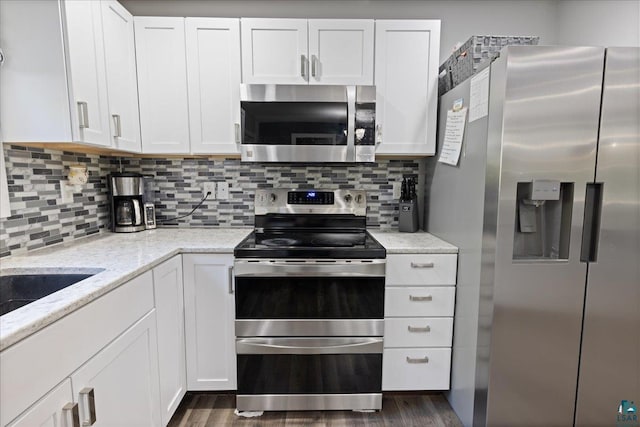 kitchen featuring stainless steel appliances, white cabinetry, and dark wood-type flooring