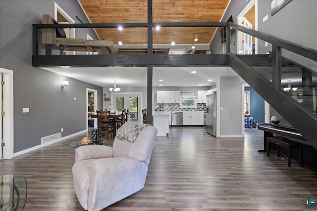 living room featuring a notable chandelier, wooden ceiling, and dark hardwood / wood-style flooring