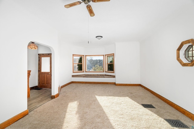 carpeted empty room featuring ceiling fan