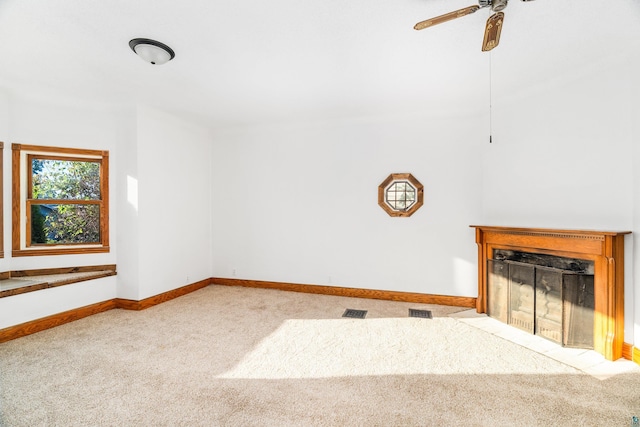 unfurnished living room featuring ceiling fan and light colored carpet