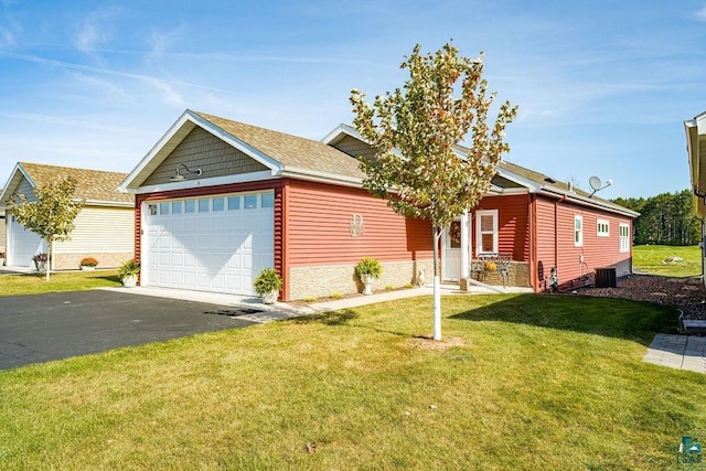 ranch-style house featuring cooling unit, a garage, and a front lawn