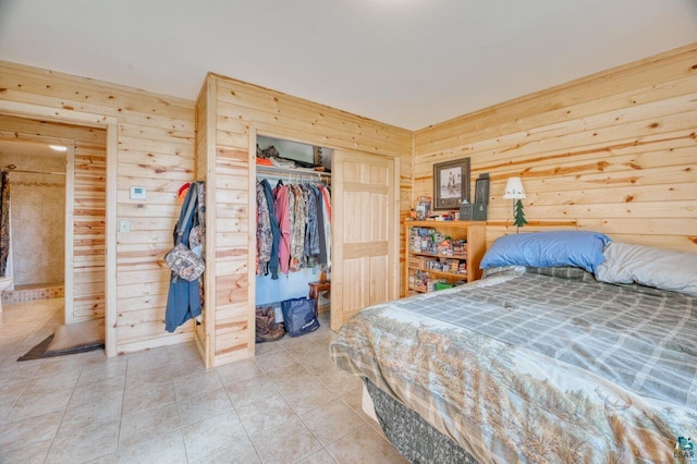 tiled bedroom featuring a closet and wood walls