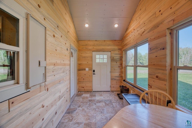 doorway with high vaulted ceiling, wooden walls, and wood ceiling