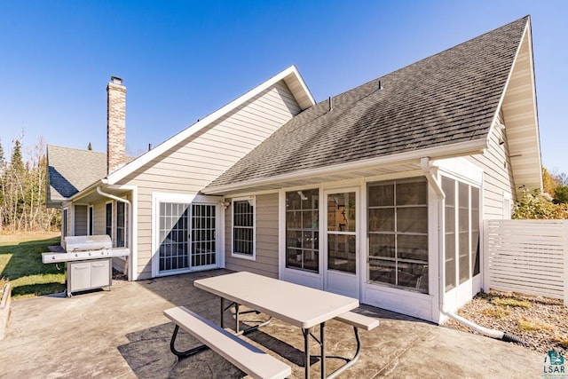 rear view of house with a patio and a sunroom