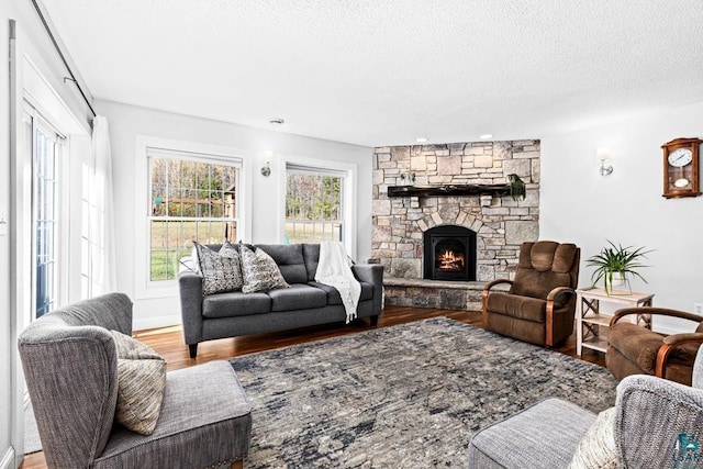 living room featuring a fireplace, wood-type flooring, and a textured ceiling