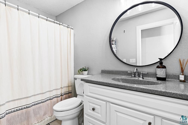 bathroom with vanity, a textured ceiling, and toilet