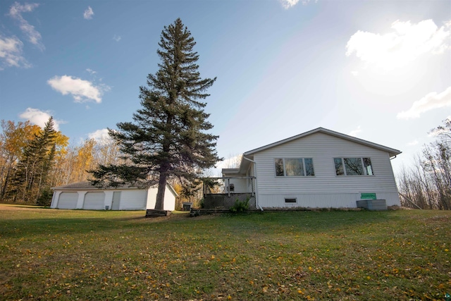 view of home's exterior with a garage, a lawn, and an outdoor structure